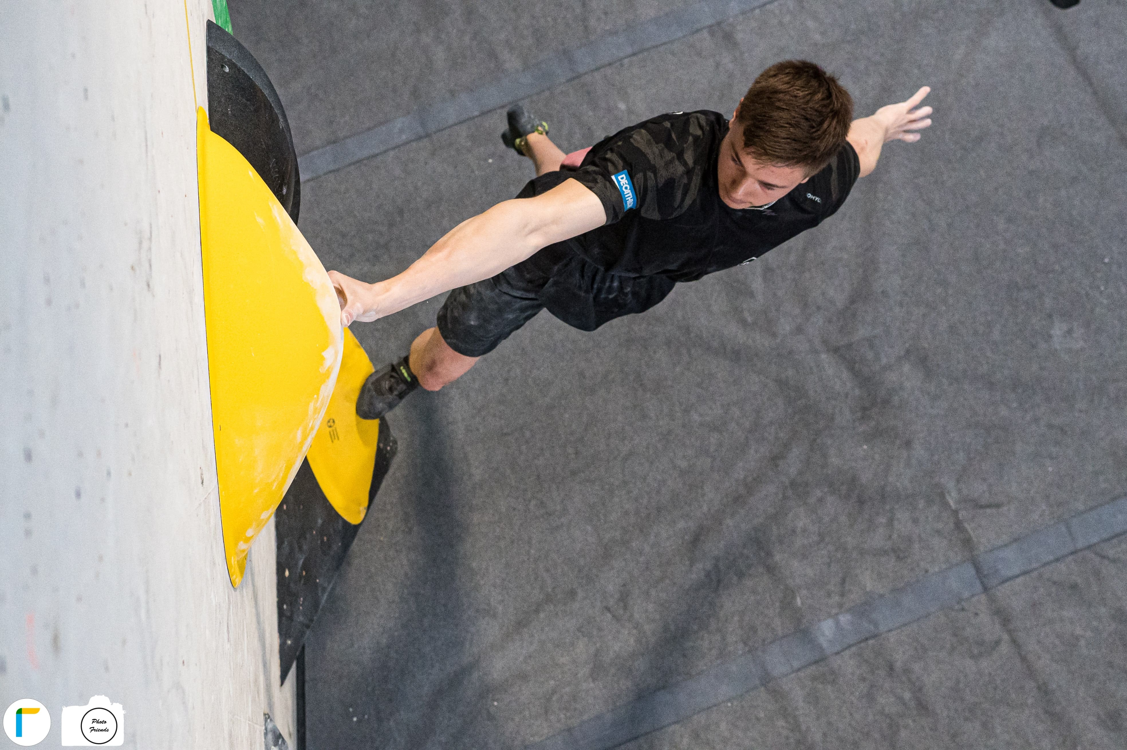 Athlet beim Bouldern im Wettkampf aus der Vogelperspektive