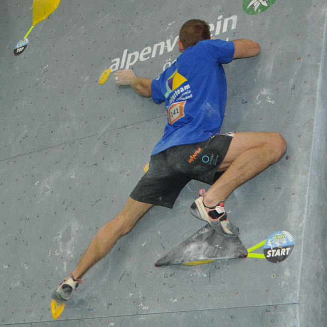 Bouldern Mann an einem Wettkampfboulder